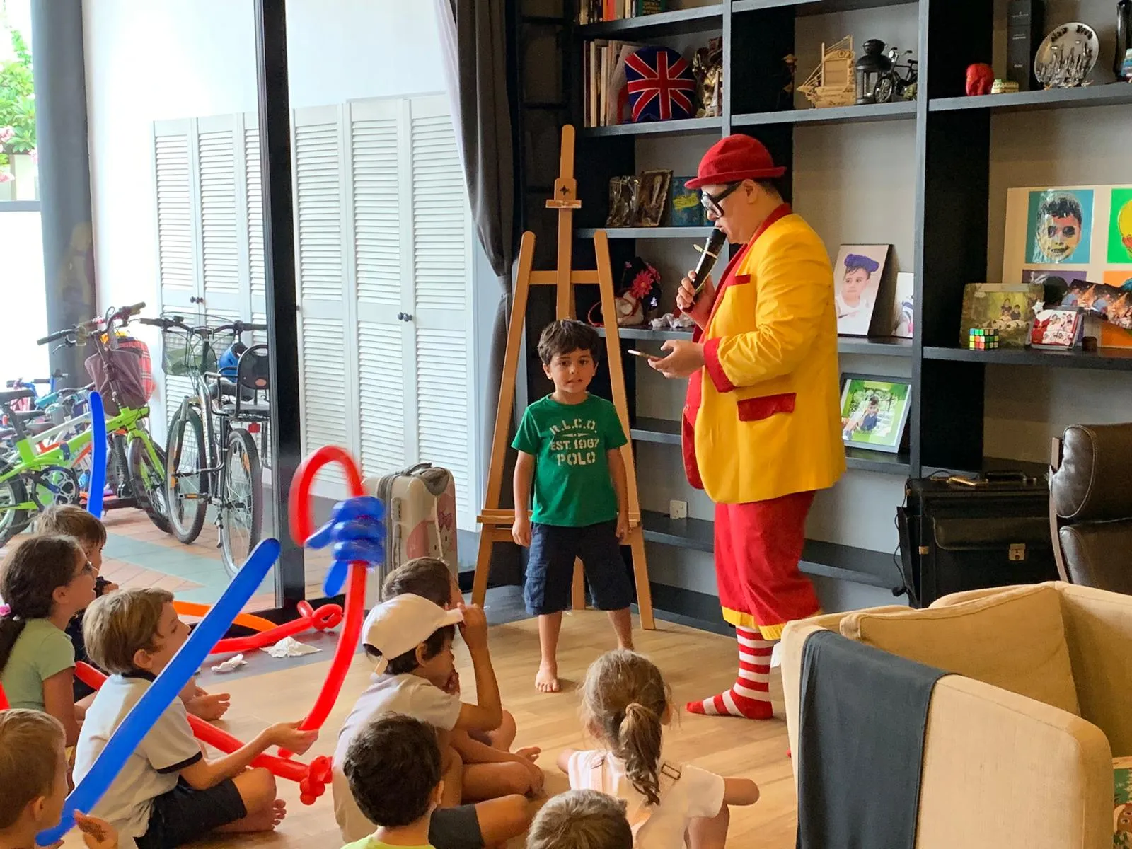 Maddie performing a comedy magic show to a room full of seated children